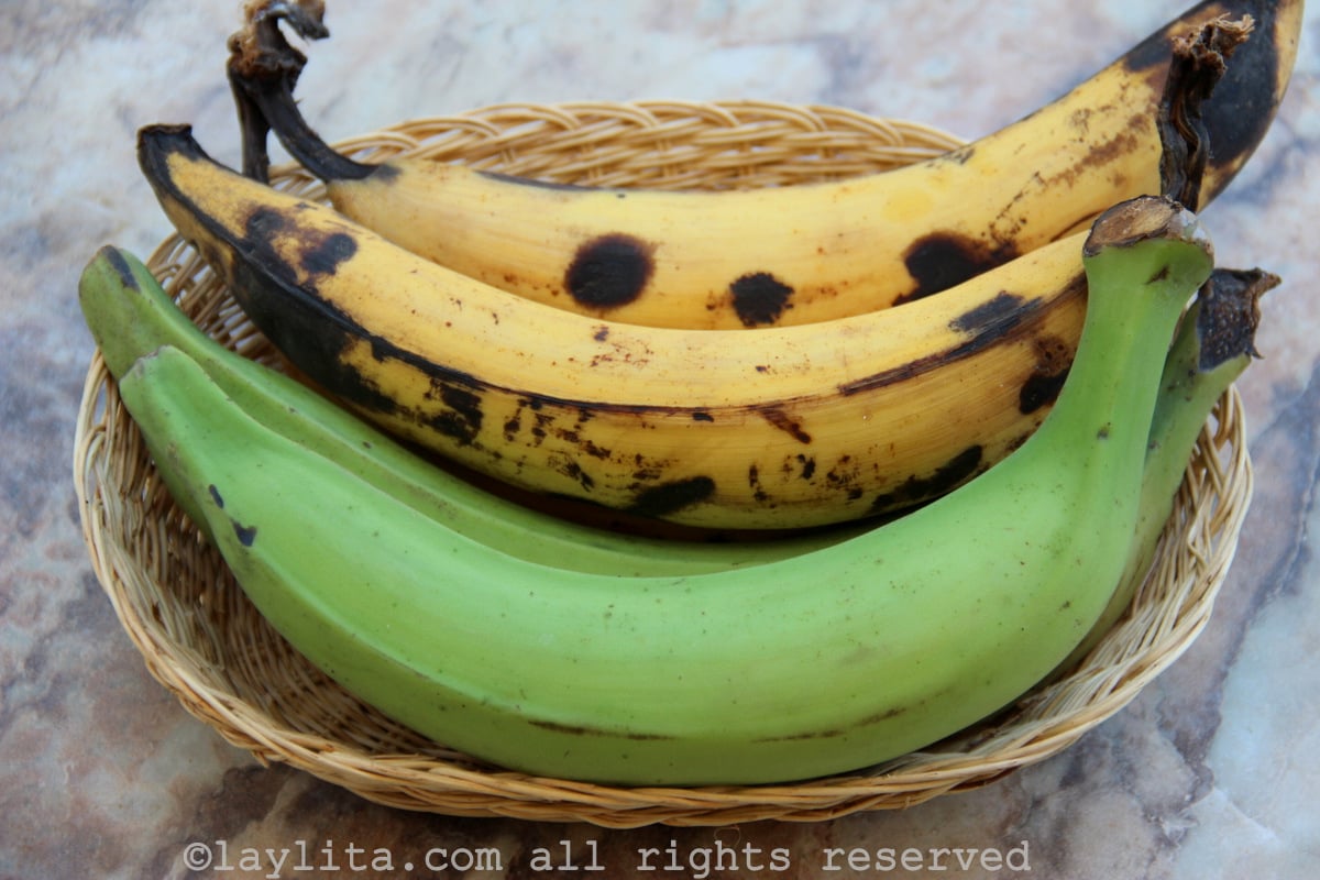 Green plantains and ripe plantains A basket with green plantains and ripe plantains on small wooden table
