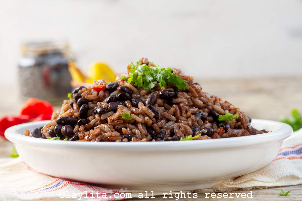 Costa Rican gallo pinto in a white bowl next to a small bowl of fried sweet plantains.