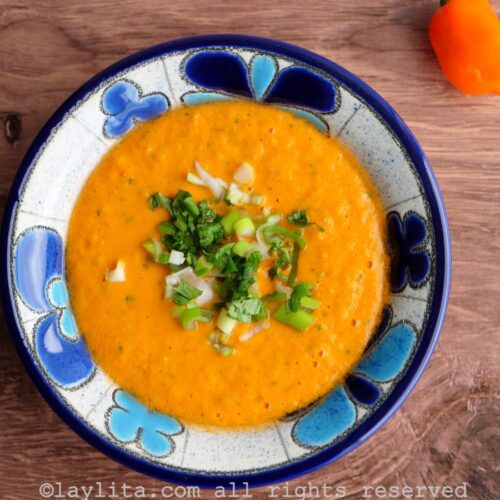 Overhead shot of aji de tomato or fake tamarillo hot sauce in a blue floral bowl on a wooden background.