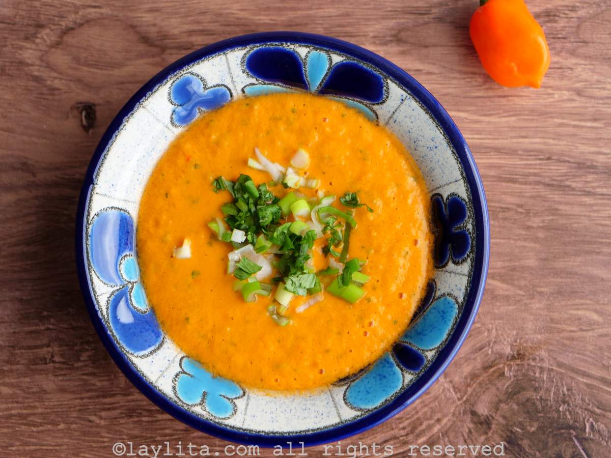 Overhead shot of aji de tomato or fake tamarillo hot sauce in a blue floral bowl on a wooden background.