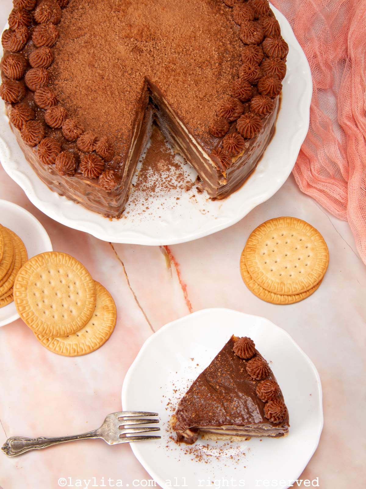 Overhead shot of a slice of marquesa de chocolate with the rest of the cake on a cake stand.