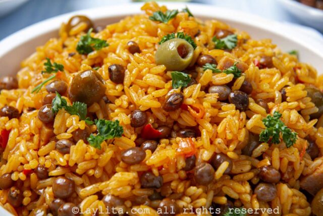 Close up of rice with pigeon peas topped with olives and chopped parsley