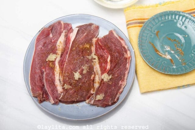 Seasoning thin beef steaks for the milanesas