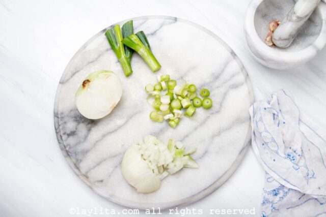 Scallions being cut on white board