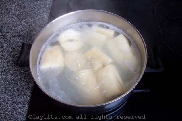 Yuca or cassava boiling in a pot on the stove