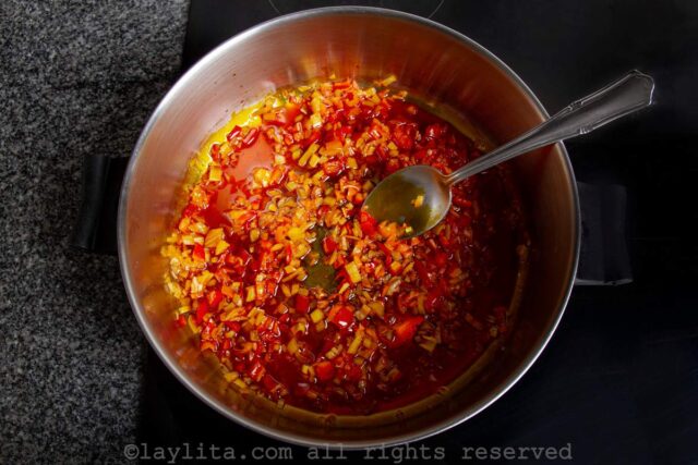 Onions cooking in achiote oil in a saucepan