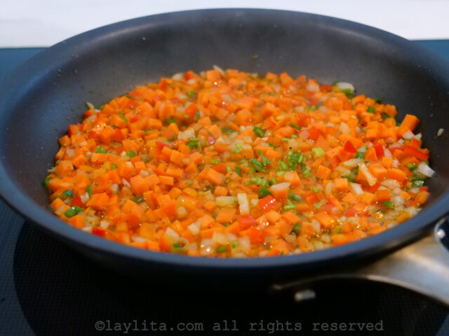 Finely diced vegetables sauteeing in a black skillet