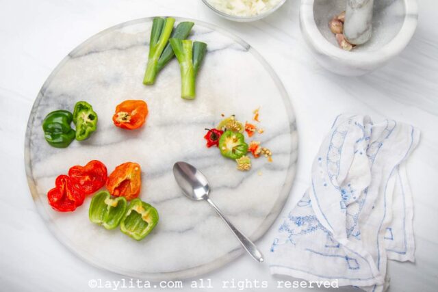 Peppers being cut on a white marble board