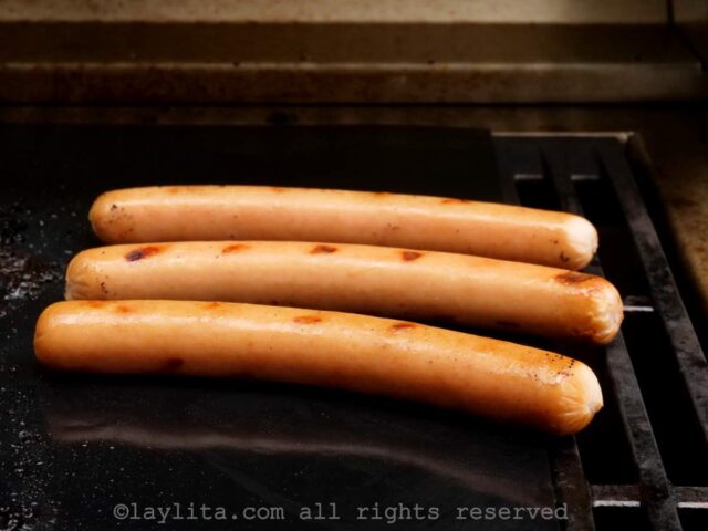 Three hot dogs on a grill