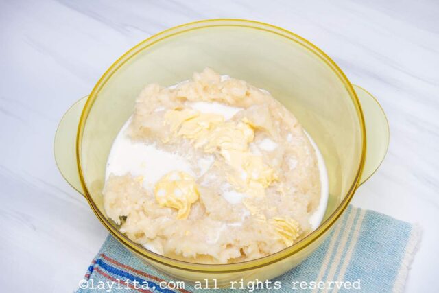 Adding milk and butter to yuca purée