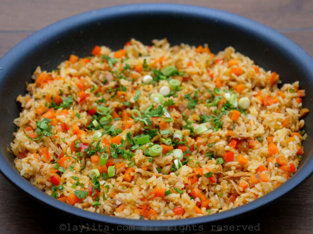 Tuna fish fried rice in a skillet topped with chopped cilantro and green onions