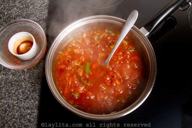 Cooking tomatoes, onions and peppers for Cuban sofrito