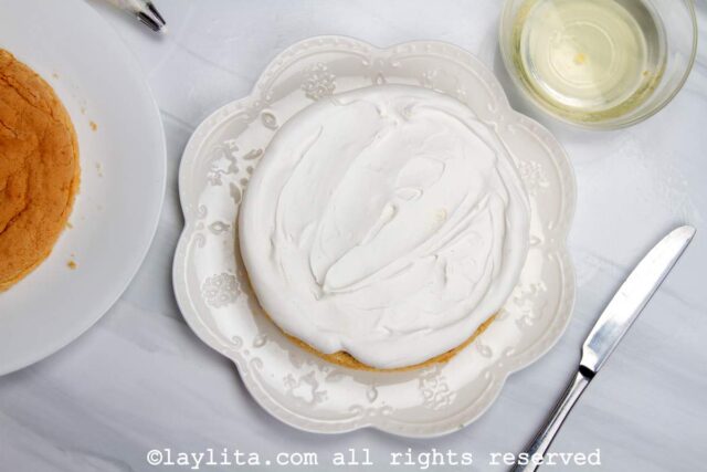 Adding the meringue disc on top of the dulce de leche layer