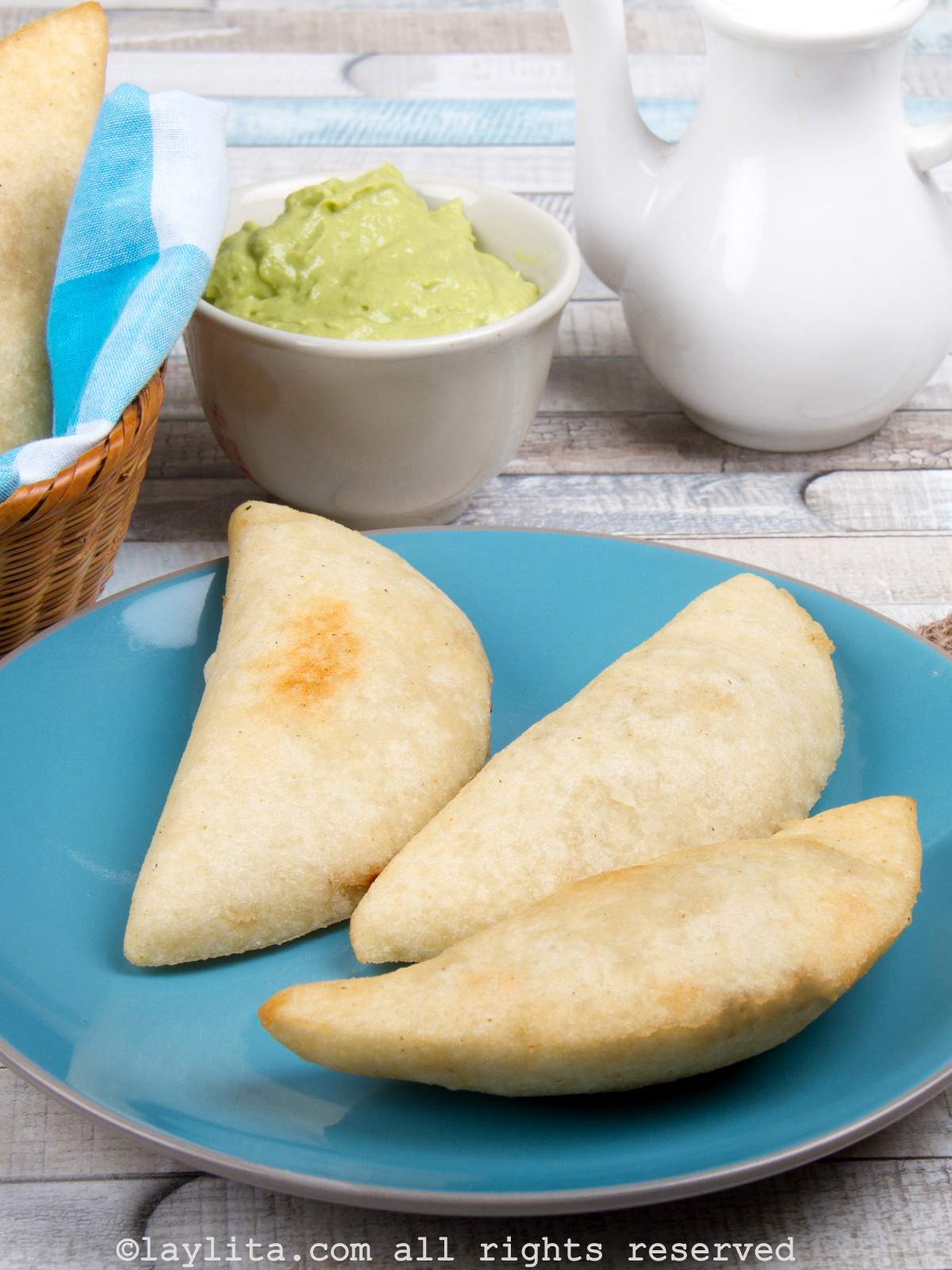 Overhead shot of three Venezuelan empanadas on a blue plate.