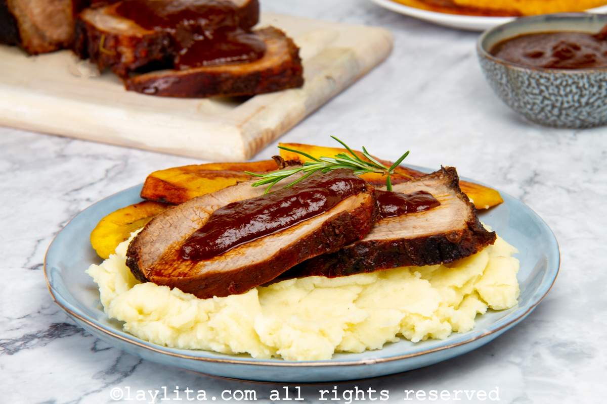 A light blue plate with mashed potatoes and Venezuelan roasted beef slices on top