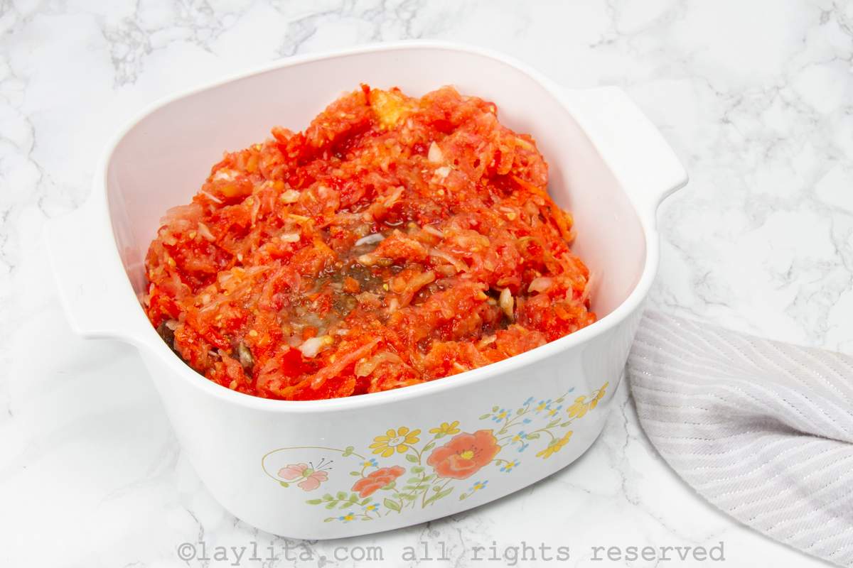 Beef roast in a dish covered with the prepared vegetable mixture.
