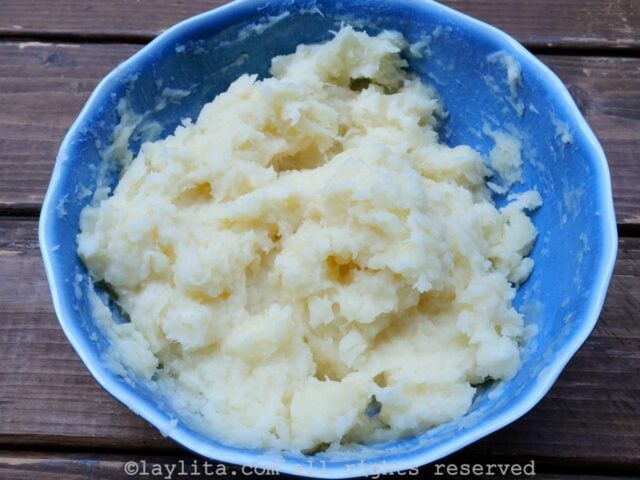 A blue bowl full of mashed yuca or mashed cassava