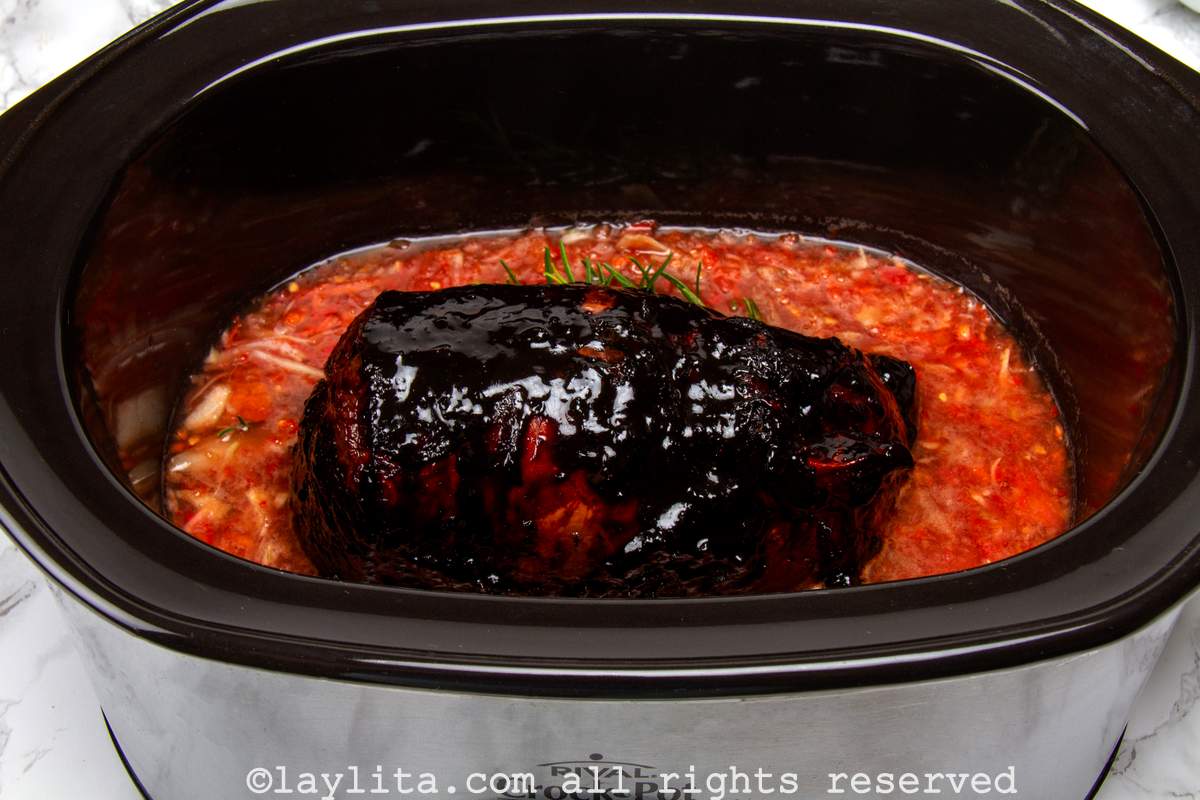 Marinade in the bottom of a crockpot with the beef roast placed on top.