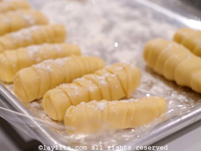 Uncooked tequeños on a platter with flour sprinkled on top