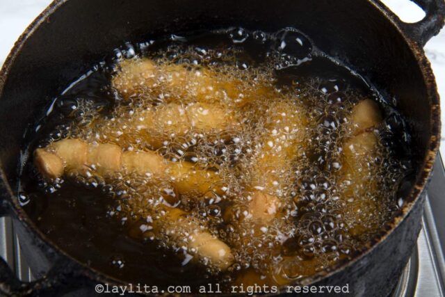 Tequeños being deep fried in oil