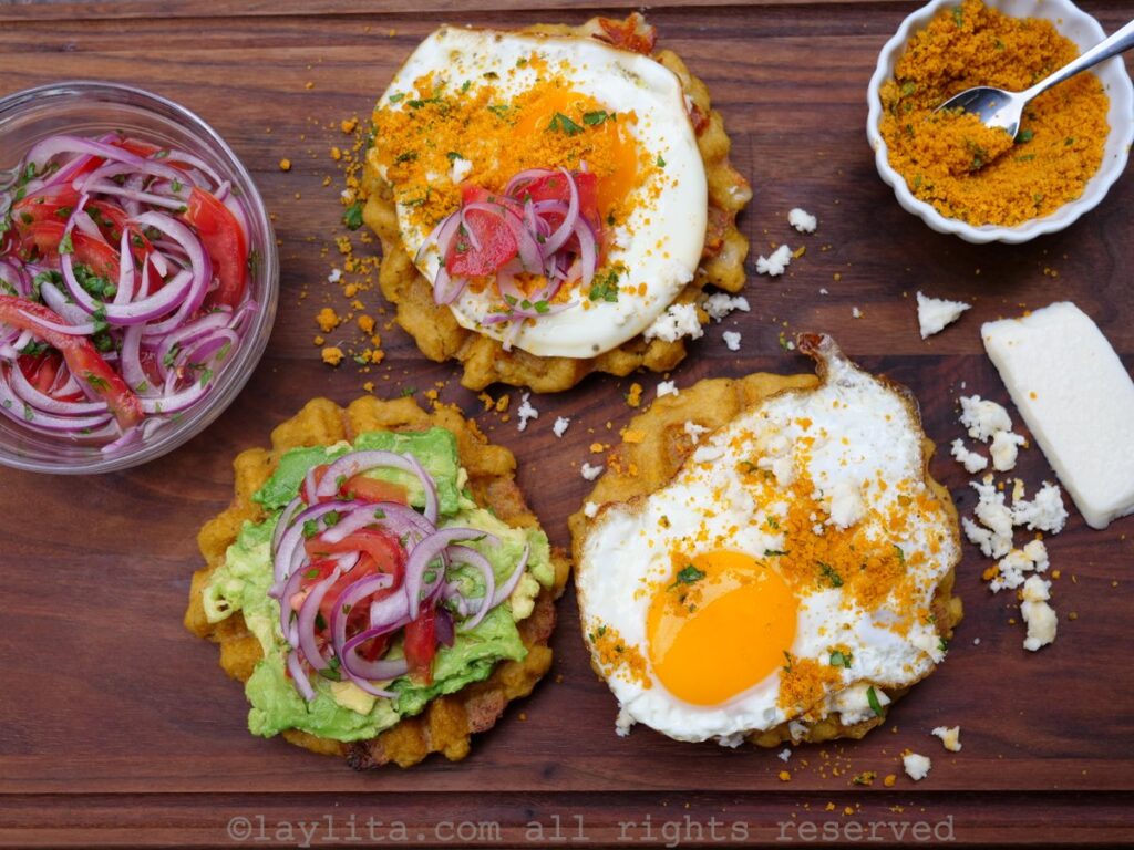 Overhead shot of three green plantain waffles with different toppings on each