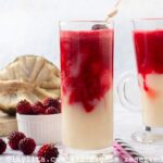 Two soursop blackberry smoothies, each in different glasses next to some fresh blackberries and an open soursop.