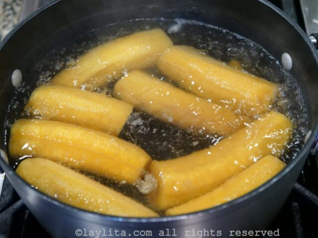 Green plantains being boiled in a pot of water