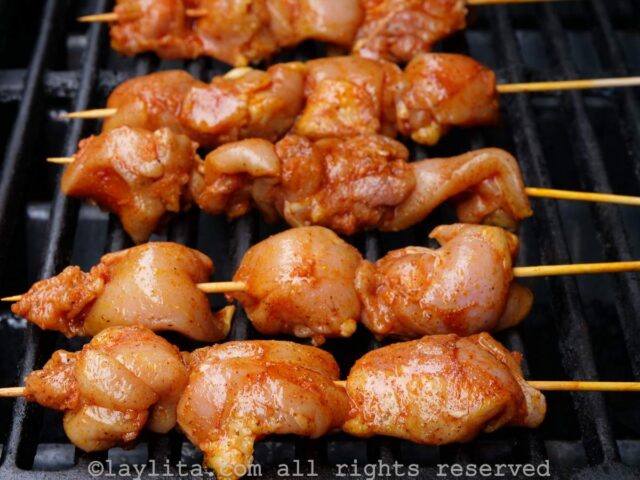 Uncooked chicken skewers on the grill