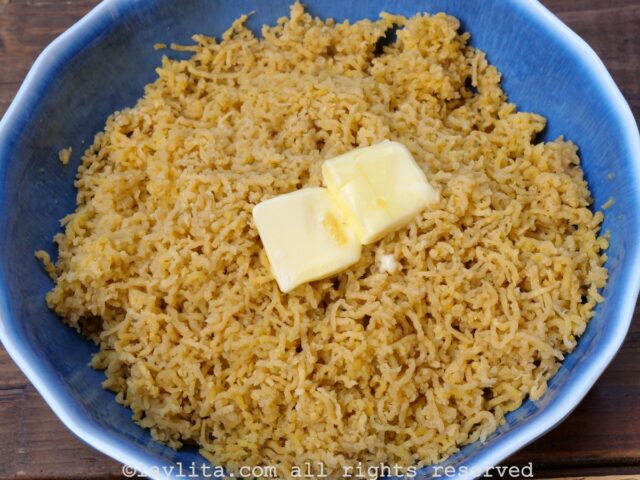 Mashed green plantains being mixed with butter, salt and garlic powder