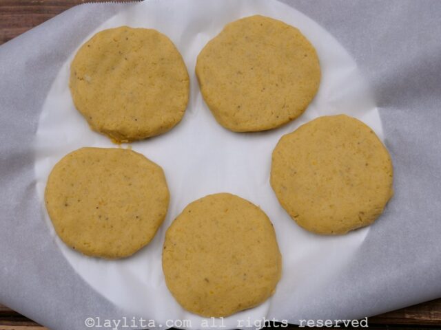5 green plantain patties on a plate lined with parchment paper