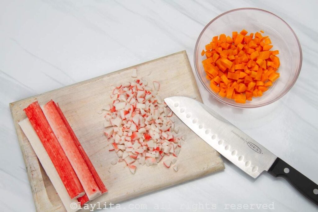 Photo of pieces of surimi on a cutting board with some cut into pieces.