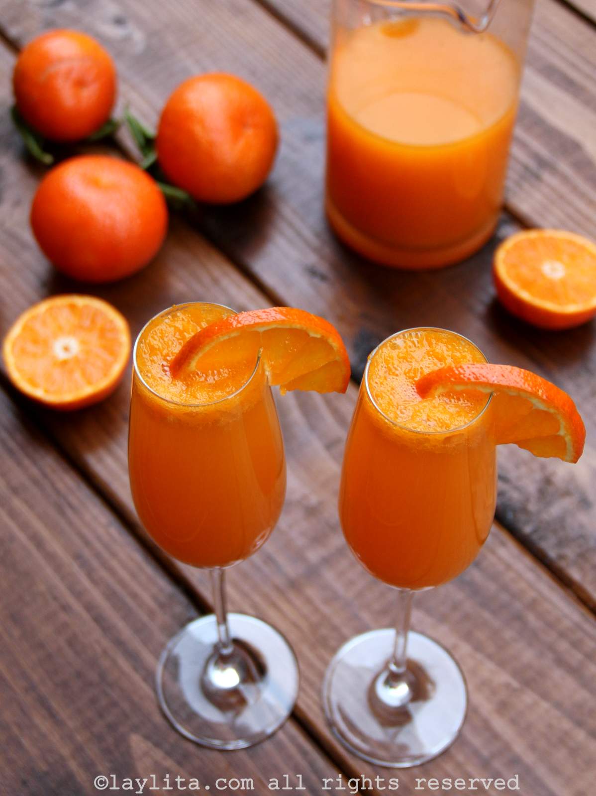 Mandarin mimosas in champagne glasses garnished with mandarin slices 