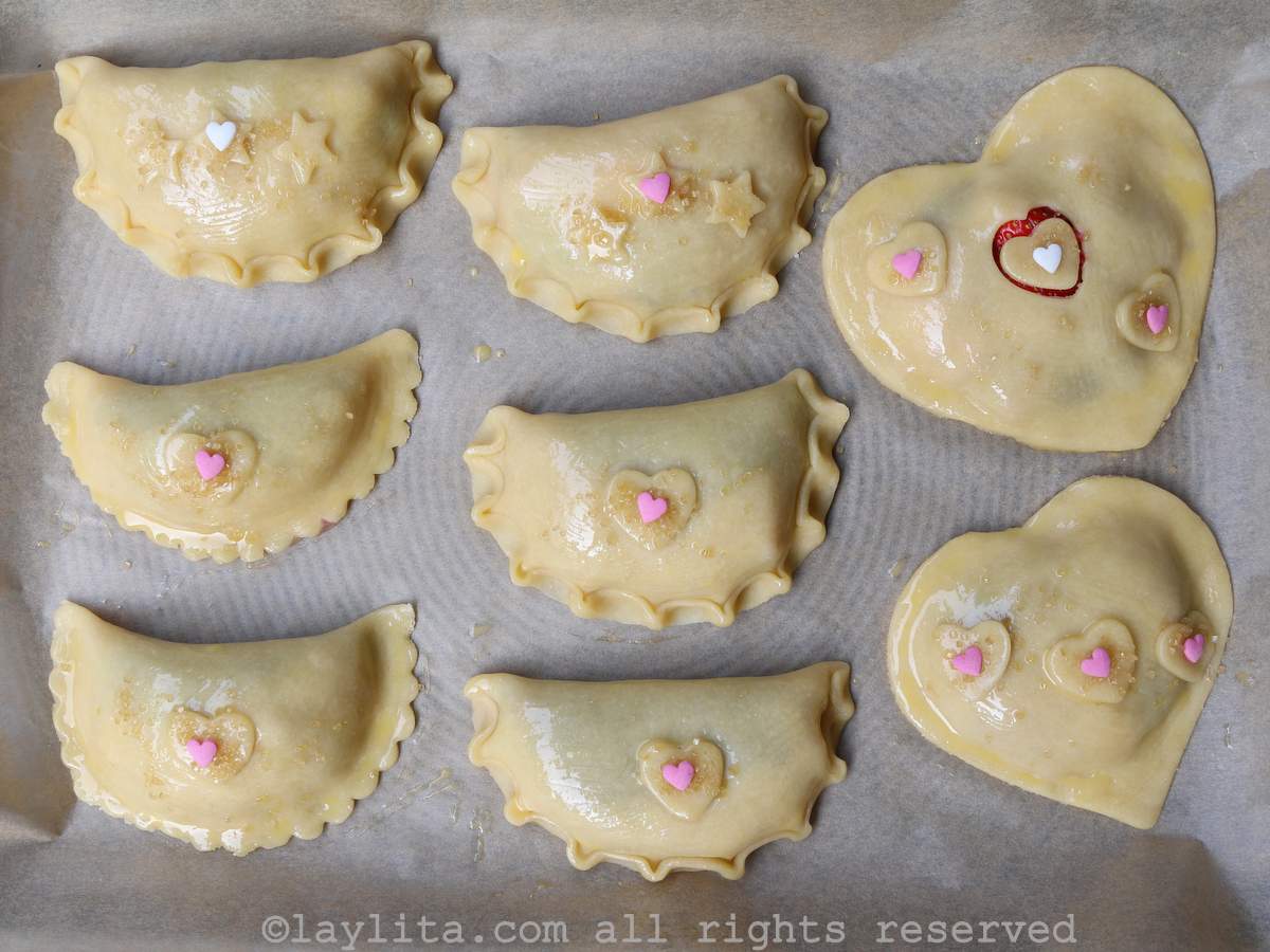 Unbaked sweet empanadas or hand pies on a baking sheet
