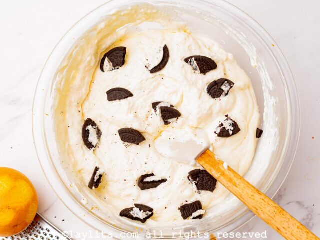 Adding crushed cookies to the cheesecake filling