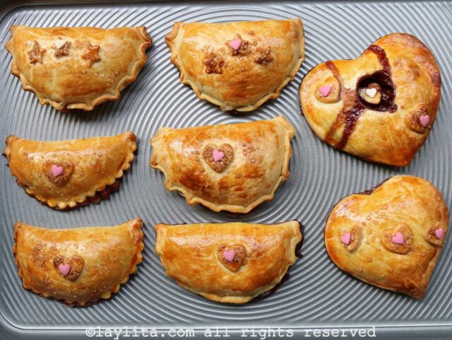 Freshly baked sweet empanadas or hand pies on a baking sheet