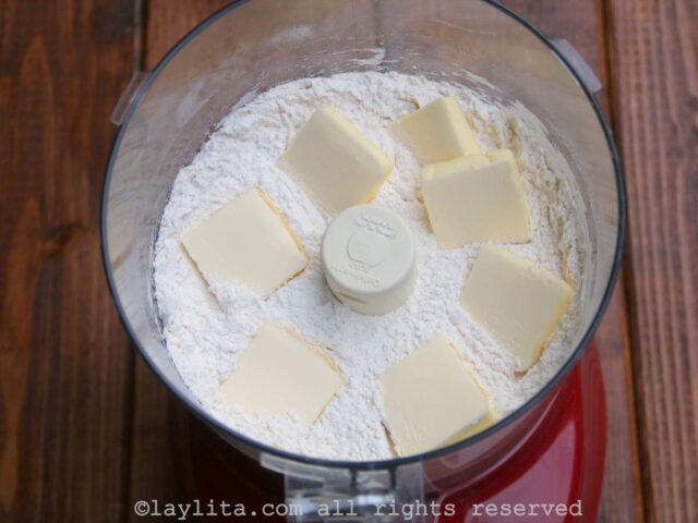 Chunks of butter being added to the flour mix in a food processor