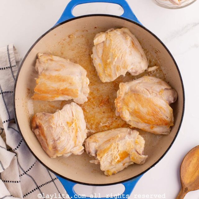 Chicken thighs browning in a pan