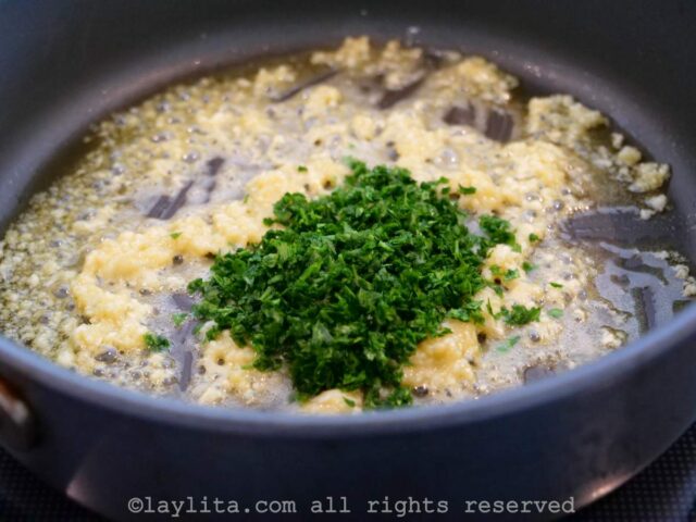 Chopped parsley and garlic cooking with olive oil in a skillet