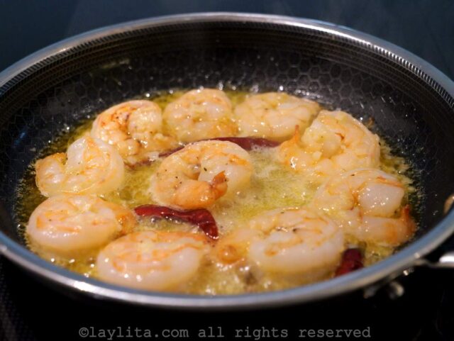 Shrimp cooking in a sauce of garlic, chili peppers and olive oil