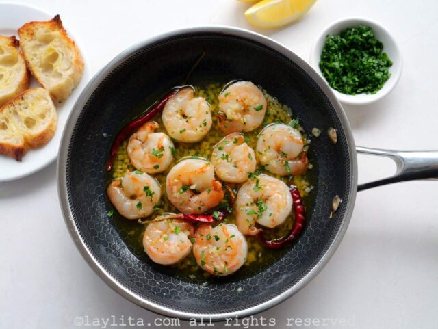 Overhead shot of gambas al ajillo after cooking in a black skillet