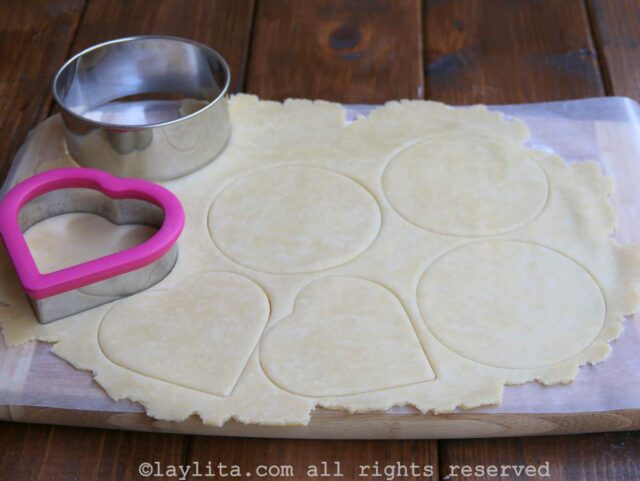 A sheet of dough rolled out and cut out into round forms and heart shapes