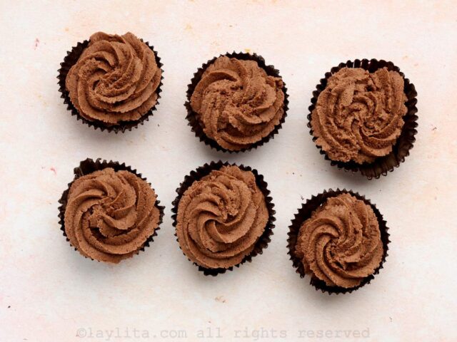 Six chocolate cups filled with chocolate mousse on a counter