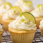 Key lime cupcake on a cooling rack with more cupcakes behind it