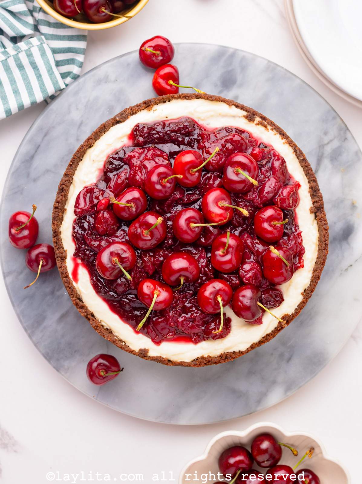 Overhead shot of cherry cheesecake on a round marble slab