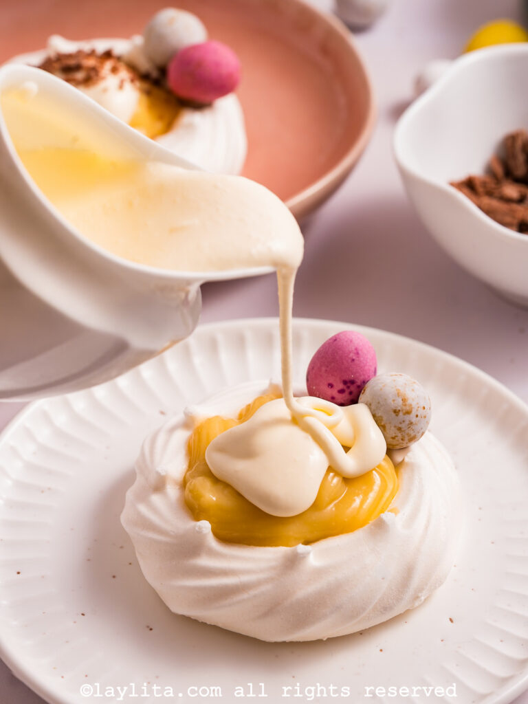 Thick cream being added to the meringue nest