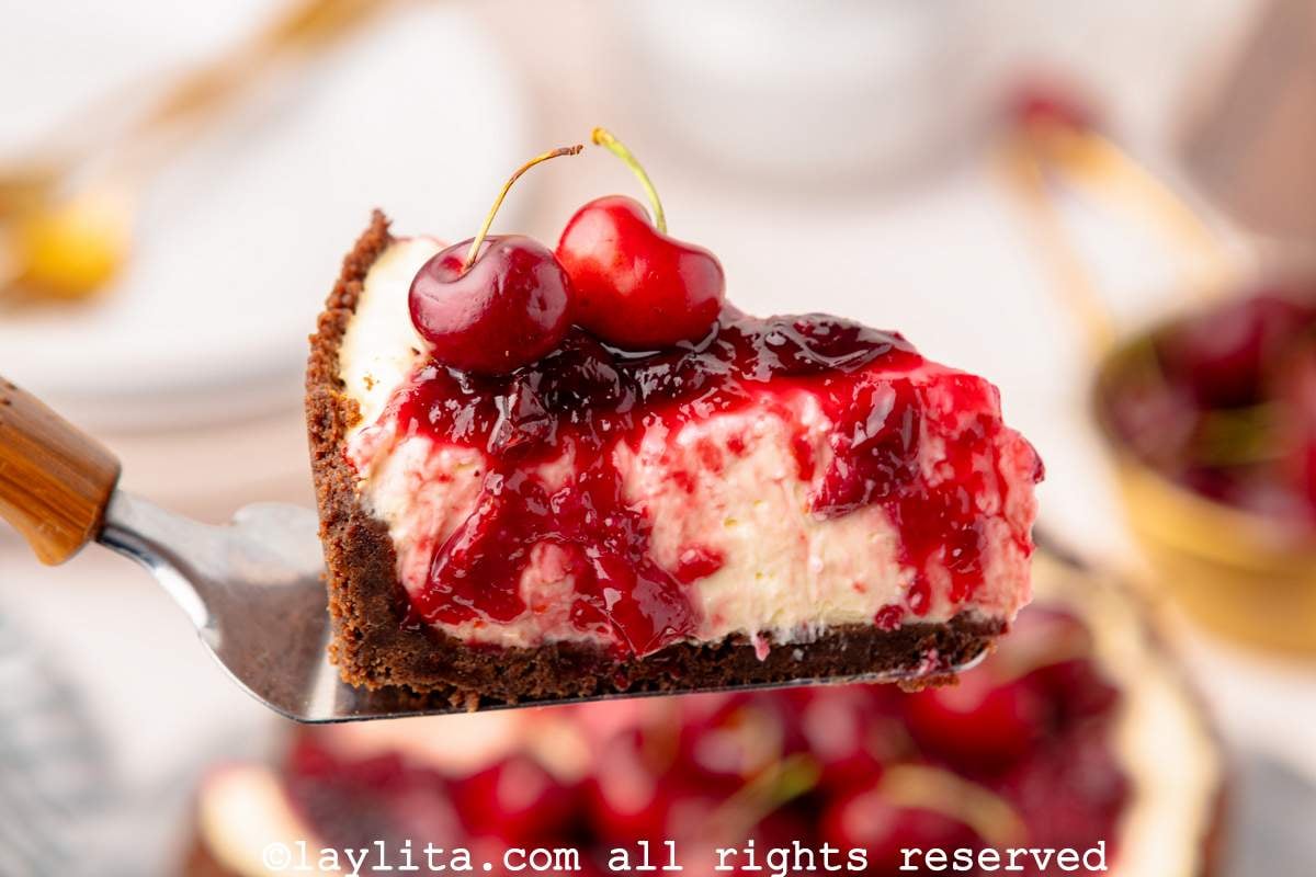 Slice of no bake cherry cheesecake on a spatula.