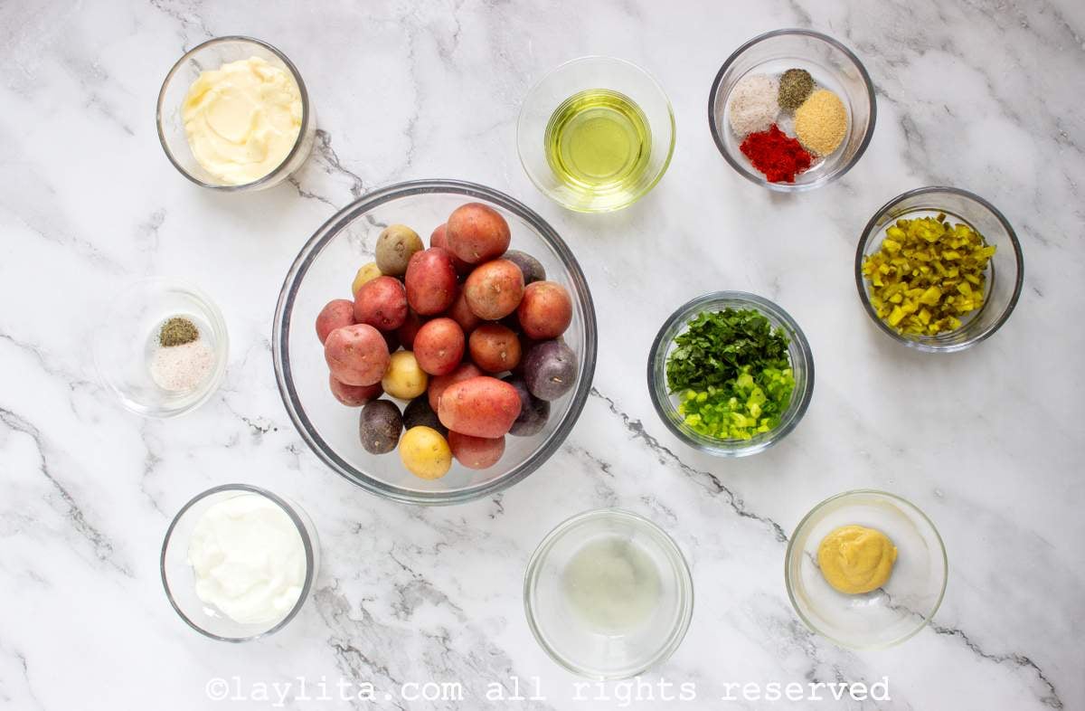 Ingredients for a crispy smashed potato salad in small bowls on a kitchen counter