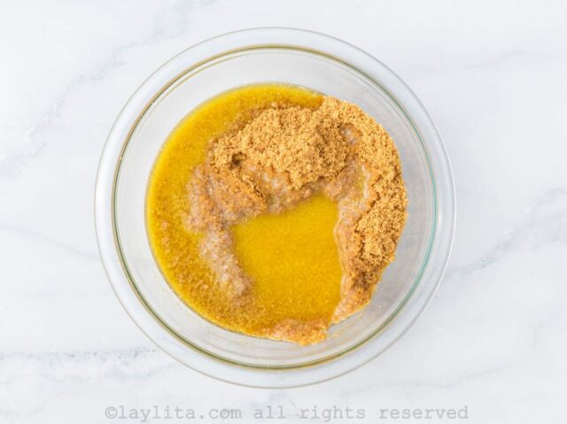 Graham cracker crumbs and melted butter in a glass bowl
