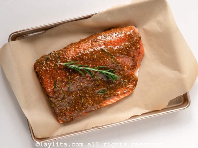 Salmon fillet on a baking sheet pan with a maple glaze rubbed in