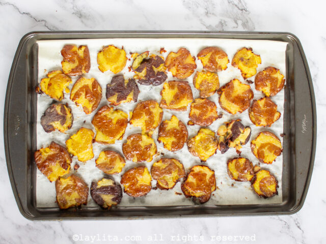 Smashed potatoes on a baking sheet after roasting in the oven